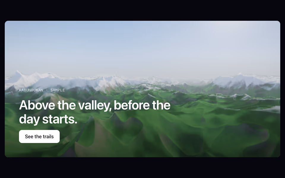 A mountain valley with green slopes, snowy peaks and a lake under a blue sky